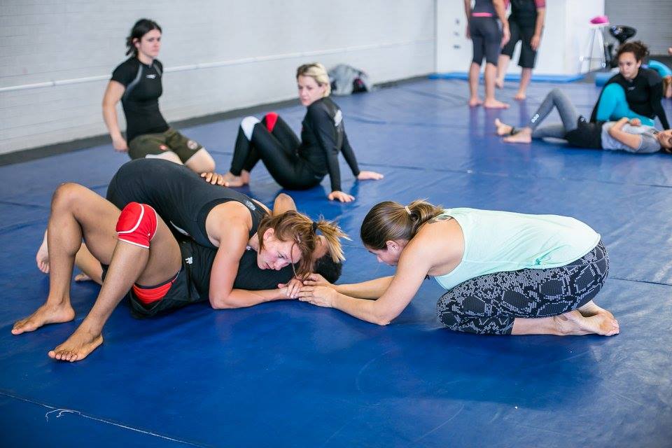 Women drilling no-gi BJJ techniques during a SAGIG session